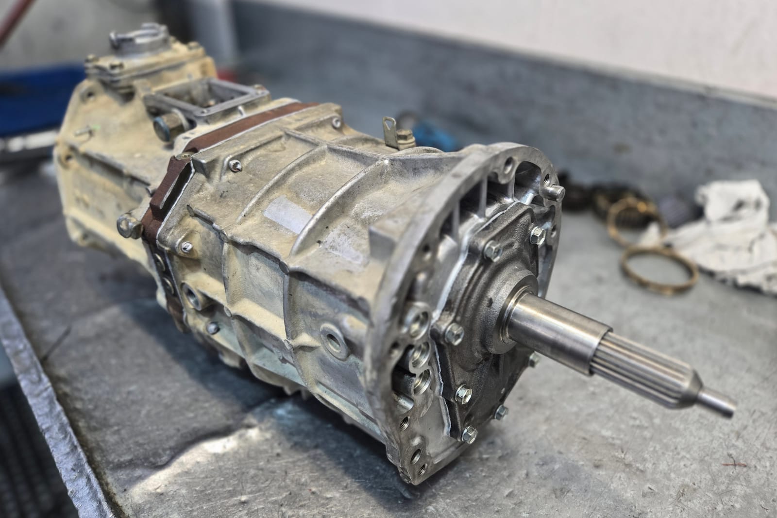 A manual gearbox on the bench at The Gearbox Company, output shaft towards the camera, with a synchro ring beside it ready for measuring