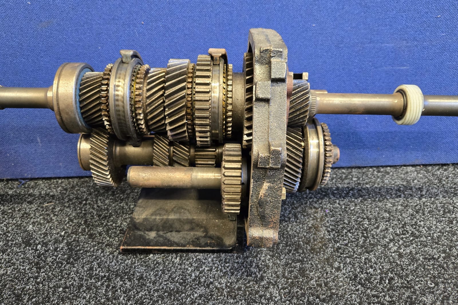 A manual gearbox geartrain out of its case on the bench, every gear, synchro hub and bearing exposed for measuring